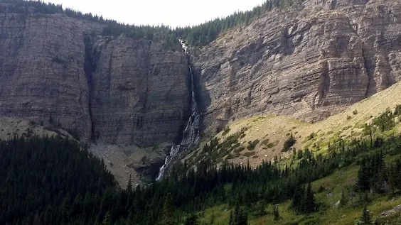 Image of Lineham falls in Waterton National Park, a waterfall that falls from the peaks of Mount Lineham, showing the mountain's cliff face.